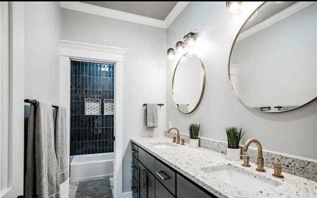 bathroom with tiled shower / bath combo, crown molding, and vanity