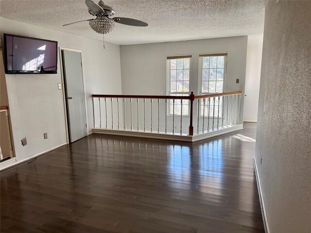 spare room featuring dark wood-type flooring and a textured ceiling