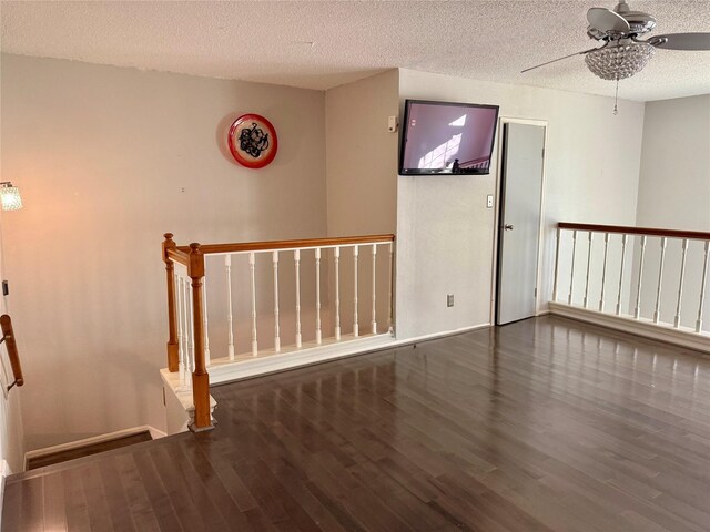 empty room with dark hardwood / wood-style flooring and a textured ceiling