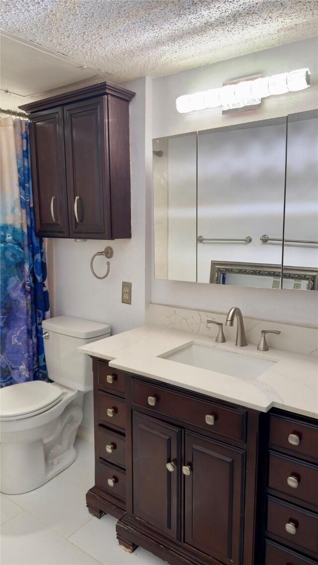 bathroom with toilet, a textured ceiling, vanity, curtained shower, and tile patterned flooring