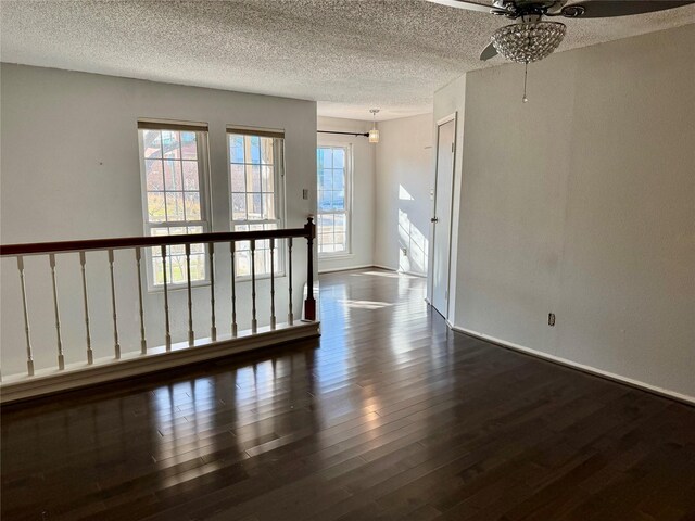 empty room with dark hardwood / wood-style flooring and a textured ceiling