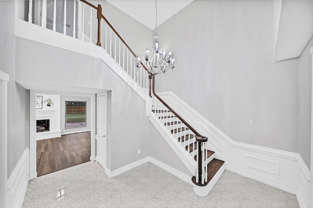 staircase with a high ceiling and a chandelier