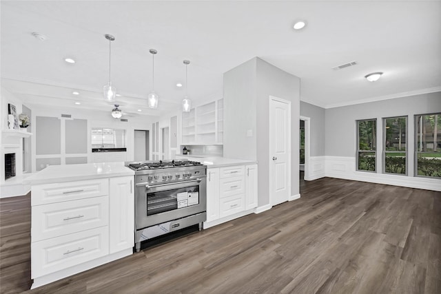 kitchen featuring white cabinetry, dark wood-type flooring, stainless steel stove, and pendant lighting