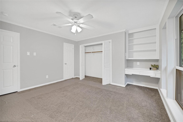 unfurnished bedroom with crown molding, carpet, built in desk, and ceiling fan