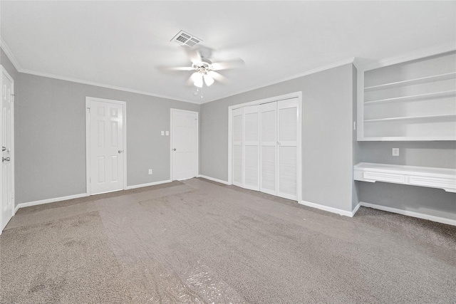 unfurnished bedroom with ornamental molding, carpet, ceiling fan, and a closet