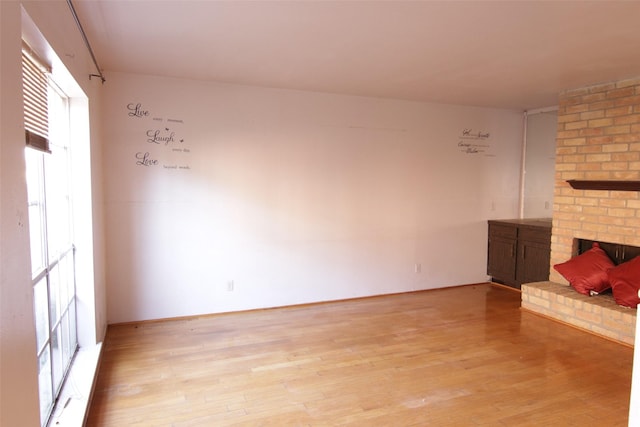 unfurnished living room with a fireplace and light hardwood / wood-style flooring