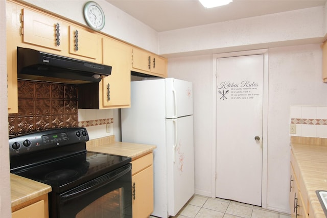 kitchen with black range with electric cooktop, white fridge, and light tile patterned floors