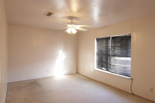 spare room with light carpet and ceiling fan