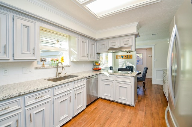 kitchen featuring sink, crown molding, dishwasher, kitchen peninsula, and white fridge