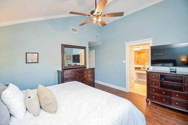 bedroom with lofted ceiling, connected bathroom, crown molding, dark hardwood / wood-style flooring, and ceiling fan