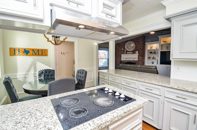 kitchen with white cabinetry, ornamental molding, black electric cooktop, and exhaust hood