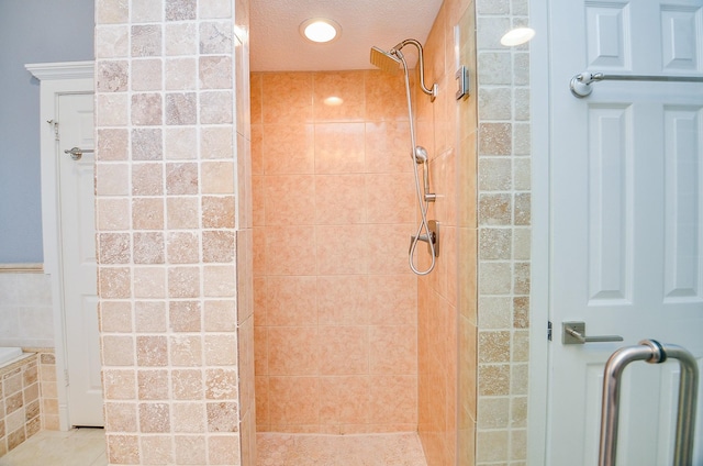 bathroom featuring tile patterned flooring, a shower with door, and a textured ceiling