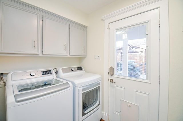 washroom featuring washer and clothes dryer and cabinets