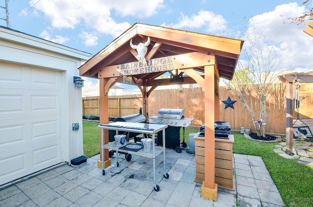 view of patio / terrace featuring a gazebo, a grill, and a garage