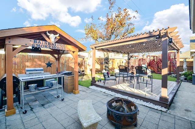 view of patio with a playground, a pergola, and a fire pit