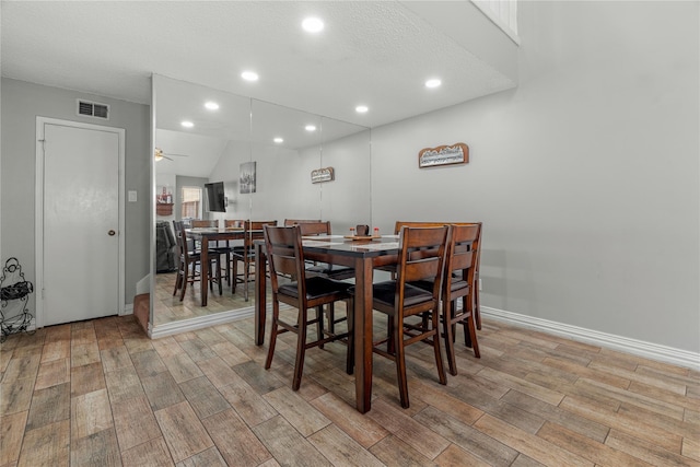 dining room featuring a textured ceiling, light hardwood / wood-style flooring, and ceiling fan