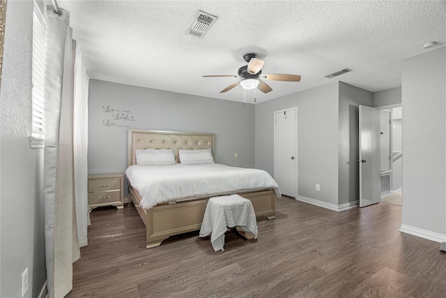 bedroom featuring a textured ceiling, dark wood-type flooring, and ceiling fan