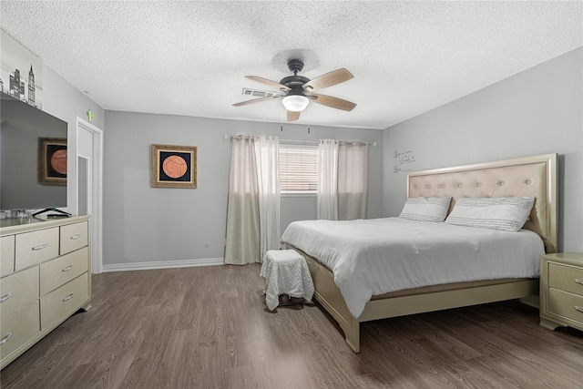 bedroom featuring hardwood / wood-style floors, a textured ceiling, and ceiling fan