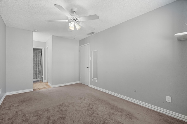 carpeted spare room featuring ceiling fan and a textured ceiling