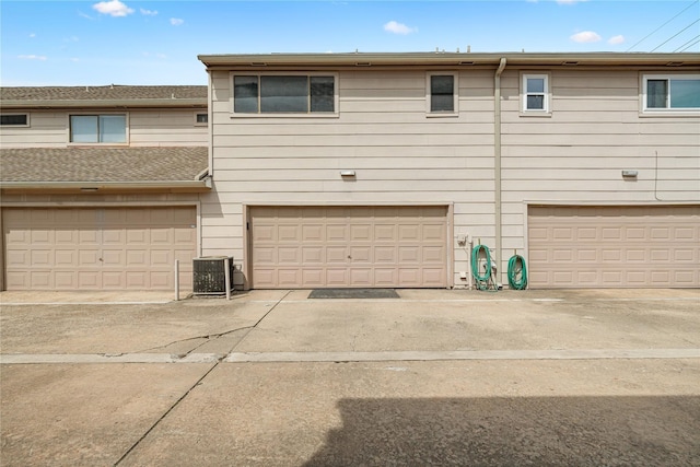 view of front facade with a garage and central air condition unit