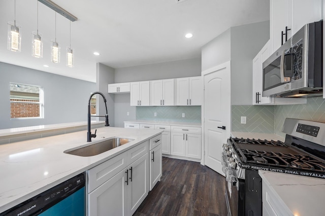 kitchen featuring sink, stainless steel appliances, light stone countertops, white cabinets, and decorative light fixtures