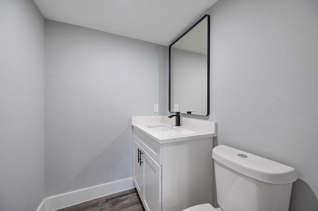 bathroom with vanity, toilet, and hardwood / wood-style floors