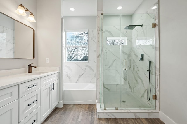 bathroom with hardwood / wood-style flooring, vanity, and separate shower and tub