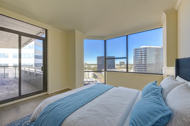 bedroom featuring multiple windows, crown molding, access to outside, and wood-type flooring