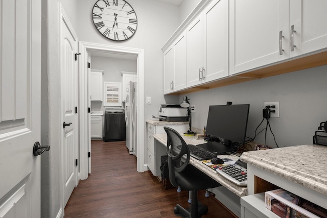 office featuring dark hardwood / wood-style floors, built in desk, and washer / clothes dryer