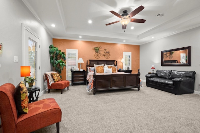 carpeted bedroom featuring crown molding, a tray ceiling, and ceiling fan