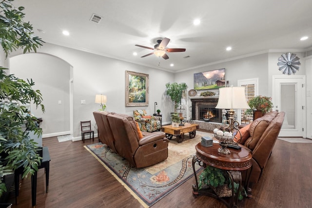 living room with crown molding, dark wood-type flooring, and ceiling fan