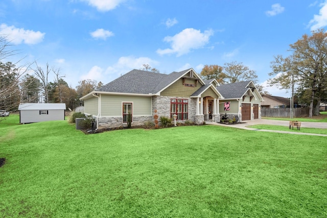 craftsman-style house with an outbuilding, a garage, and a front yard