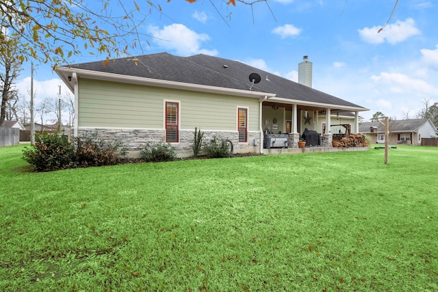 rear view of property featuring a yard and a patio area