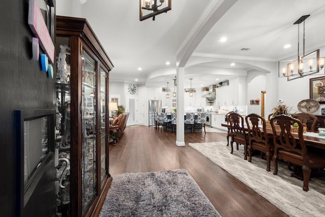 dining room with crown molding, dark hardwood / wood-style floors, and a notable chandelier