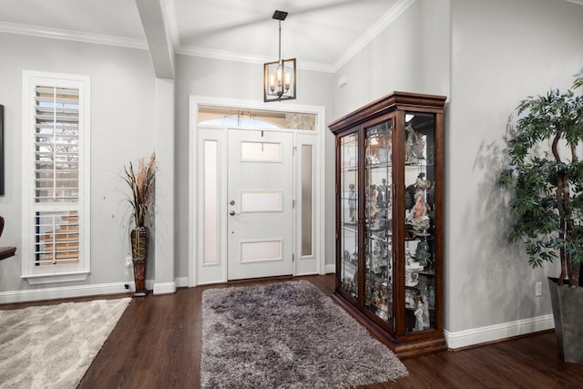 entryway featuring dark wood-type flooring, ornamental molding, a chandelier, and plenty of natural light