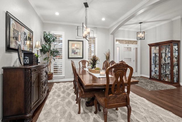 dining room featuring crown molding, light hardwood / wood-style floors, and a notable chandelier