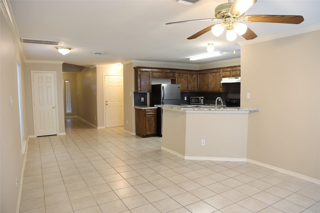 kitchen featuring light stone counters, ornamental molding, appliances with stainless steel finishes, and light tile patterned floors