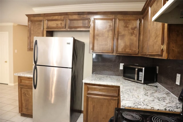 kitchen with light stone counters, light tile patterned floors, ornamental molding, stainless steel appliances, and decorative backsplash