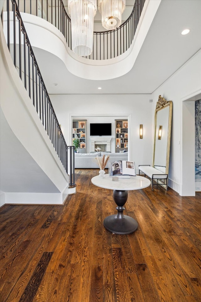 foyer with an inviting chandelier, wood-type flooring, and a high ceiling