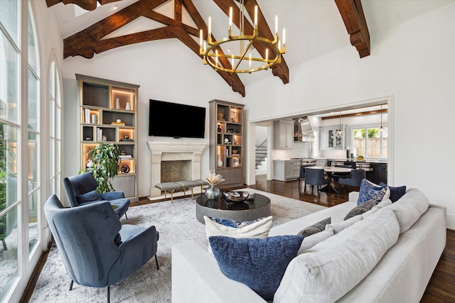 living room featuring beam ceiling, wood-type flooring, a chandelier, high vaulted ceiling, and a premium fireplace