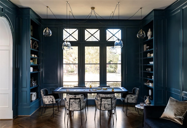 dining space featuring dark parquet flooring and built in features