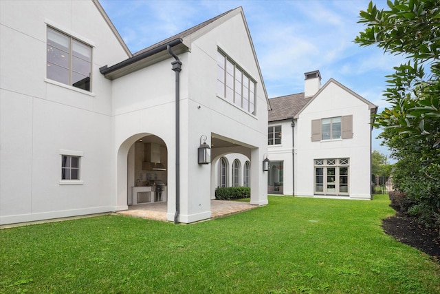 back of house featuring a patio and a yard