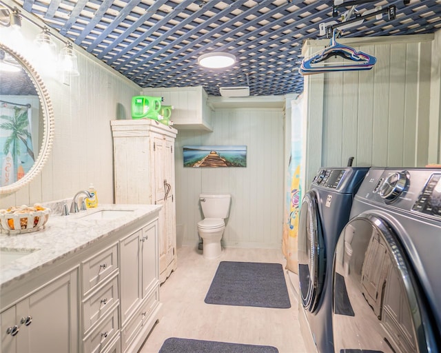 washroom featuring separate washer and dryer, sink, and light wood-type flooring