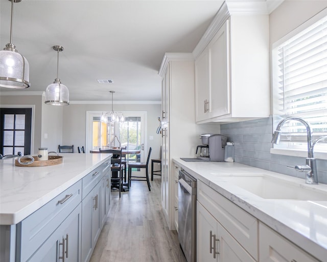 kitchen with sink, crown molding, white cabinetry, decorative light fixtures, and stainless steel dishwasher