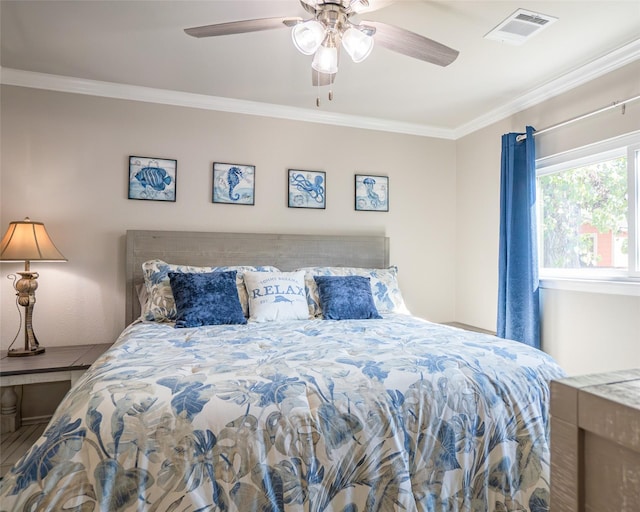 bedroom featuring hardwood / wood-style floors, ornamental molding, and ceiling fan