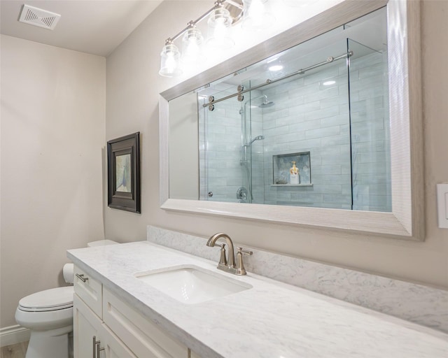 bathroom featuring vanity, an enclosed shower, and toilet