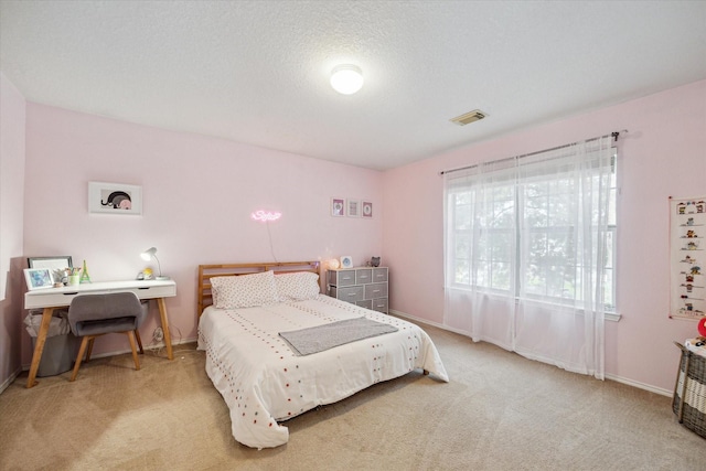 bedroom featuring a textured ceiling and light colored carpet