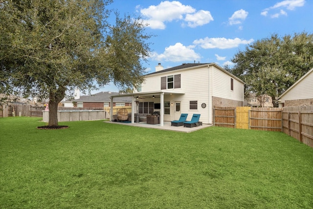 rear view of house featuring a lawn and a patio area