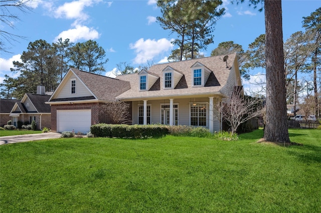 cape cod home featuring driveway, brick siding, roof with shingles, and a front yard