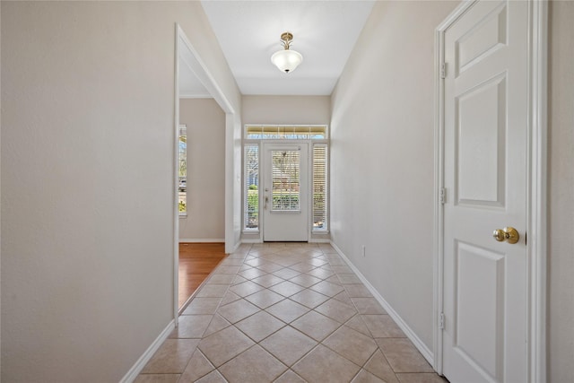 foyer with light tile patterned flooring and baseboards